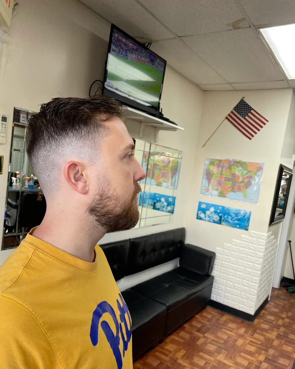 Fresh skin fade with a full, shaped beard, side profile, at Pearl River Barber Shop
