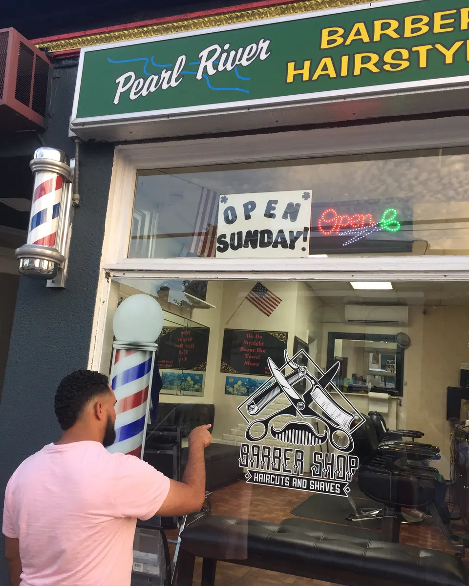 Pearl River Barber Shop storefront on Central Ave, with the barber pole and an Open Sunday sign in the window